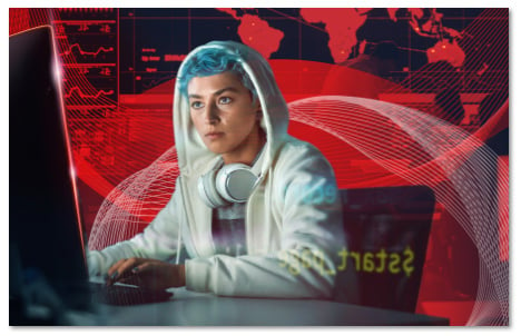 Blue-haired woman in a white hoodie looking at a monitor