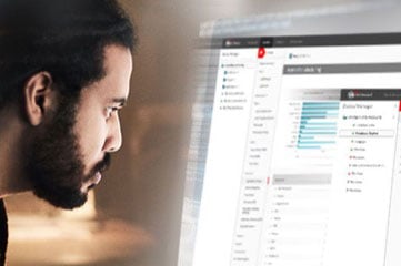 Ein schwarzer Mann mit kurzem Bart, der konzentriert auf einen Dashboard-Bildschirm von WatchGuard Cloud schaut.