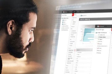 Uomo di colore con la barba corta che guarda attentamente lo schermo del dashboard di WatchGuard Cloud