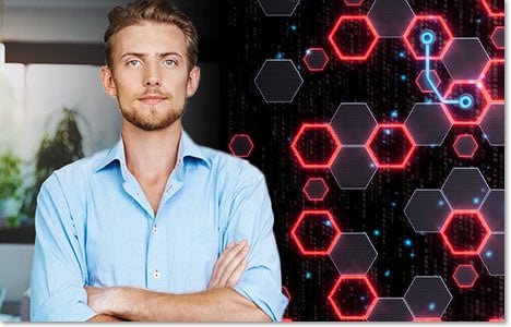 Man in a light blue button down shirt standing next to a pattern of linked hexagons with red lights